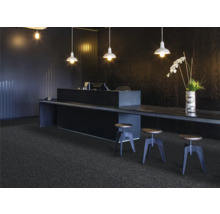 Szene mit dunklem Teppichboden, Tresen, Hockern und Beleuchtung für ein modernes Büroambiente.