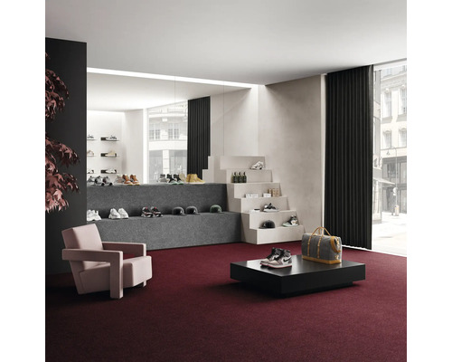 Innenraum mit Teppichboden, Sessel, Tisch und Warenpräsentation von Schuhen und Accessoires