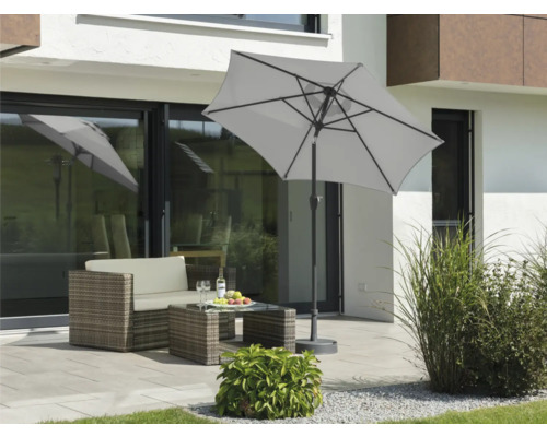 Gartenszene mit Sonnenschirm, Loungemöbeln und Dekoration auf der Terrasse