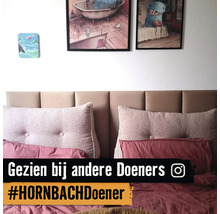 Schlafzimmer mit Bett, Kissen und Wanddekoration