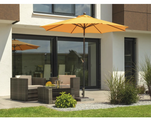 Szene mit Sonnenschirm, Sitzgruppe und Gartengestaltung vor einem modernen Haus