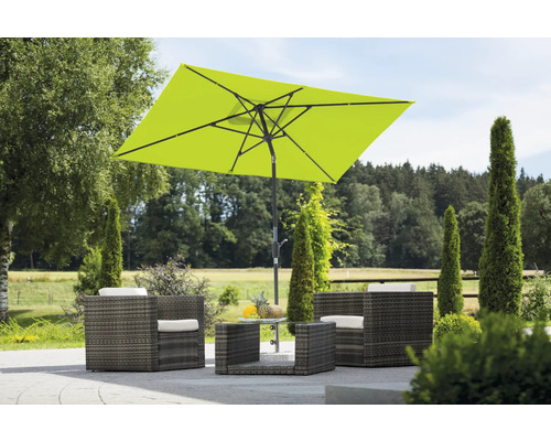 Gartenszene mit Sitzgruppe, bestehend aus Sesseln, Tisch und einem rechteckigen Sonnenschirm.