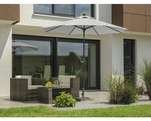 Gartenszene mit Sonnenschirm, Gartentisch und Gartenstühlen auf der Terrasse