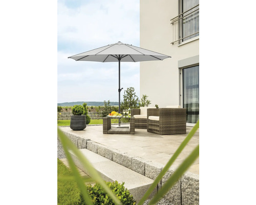 Terrasse mit Sonnenschirm, Rattanmöbeln und Steinstufen