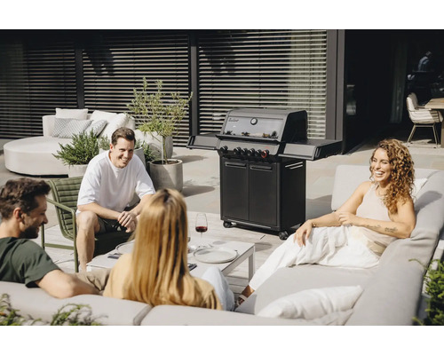 Personen sitzen um einen Gasgrill auf einer Terrasse.