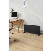 Büro mit Schreibtisch, Computer, Bürostuhl und einem schwarzen Heizkörper