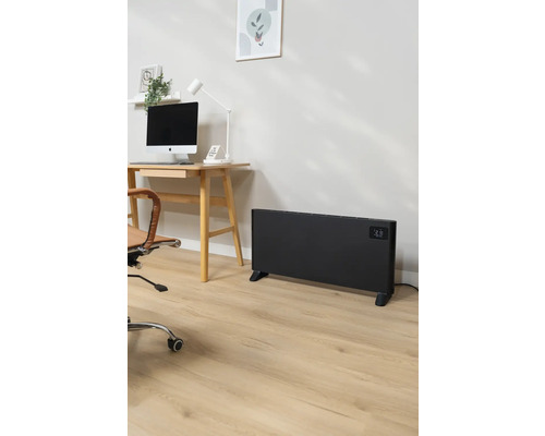 Büro mit Schreibtisch, Computer, Bürostuhl und einem schwarzen Heizkörper