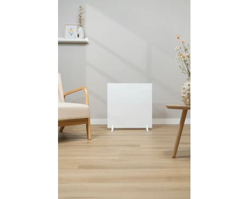 Weißer Heizkörper im Wohnzimmer neben einem Sessel und einem Beistelltisch.