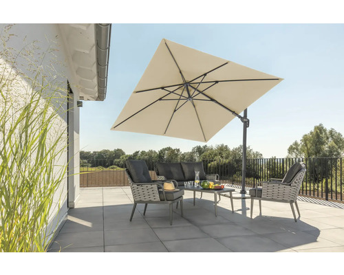 Gartenszene mit Ampelschirm, Sofa, Sesseln und Tisch auf einer Terrasse.