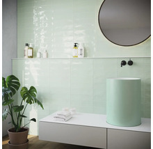 Modernes Badezimmer mit mintgrünen Fliesen, Aufsatzwaschbecken und runden Spiegel