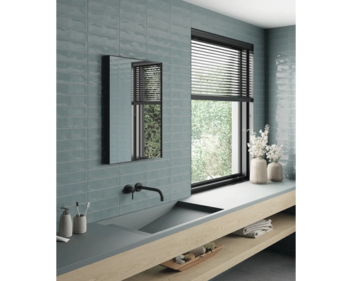 Helles Badezimmer mit Waschbecken, Spiegel, Fenster und Fliesen