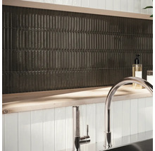 Wandgestaltung mit länglichen, dunklen Fliesen und Armatur