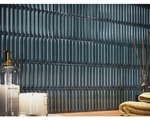 Wandfliesen in einem Badezimmer mit Kerzen und Handtüchern