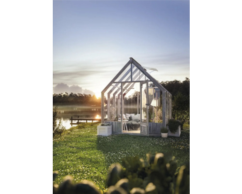 Gewächshaus im Garten mit Blick auf den See bei Sonnenaufgang.