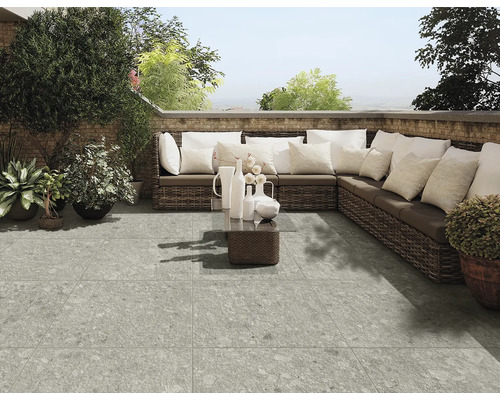 Terrasse mit grauem Fliesenboden, Rattansofa und Dekoration