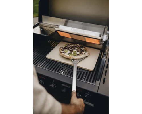 Pizza auf Pizzaschieber im Grill