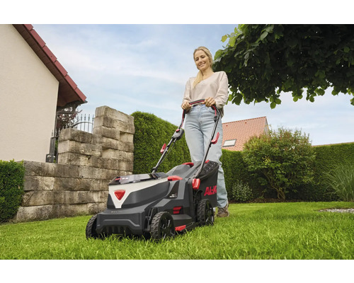 Frau benutzt einen AL-KO Akku-Rasenmäher im Garten.