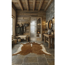 Rustikaler Eingangsbereich mit Holzwand, Steinboden und Kuhfellteppich.