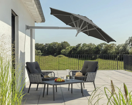 Szene mit Ampelschirm, Gartensessel und Tisch auf einer Terrasse