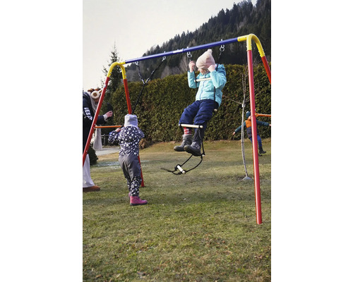 Kind auf einer Spielplatzschaukel im Garten.