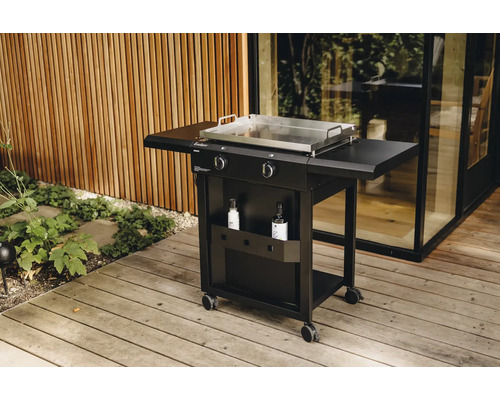 Schwarzer Gasgrill mit Seitenablagen, Edelstahlplatte und Stauraum auf einer Holzterrasse