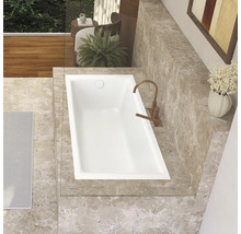 Draufsicht einer Badewanne in einem Badezimmer mit Marmorfliesen und Armatur.