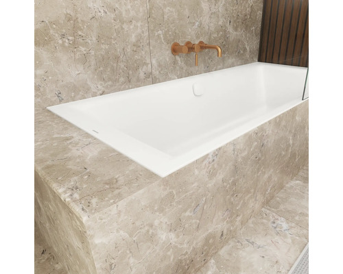 Eingebaute Badewanne mit Armatur an gefliester Wand