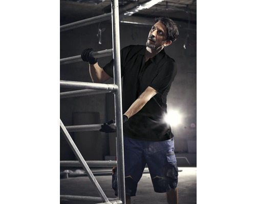 Mann mit Arbeitskleidung und Gerüst im Innenraum