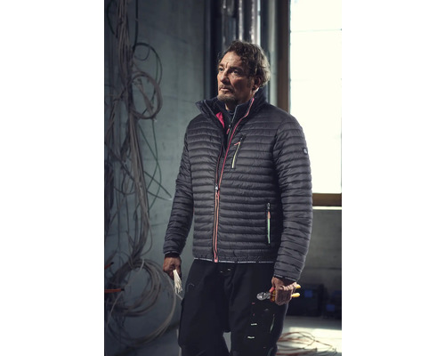 Mann in Arbeitskleidung mit Daunenjacke und Werkzeug