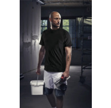 Mann in Arbeitskleidung mit Farbeimer und Maurerkelle auf einer Baustelle