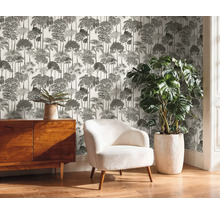 Raumansicht mit Kommode, Sessel, Zimmerpflanze und bedruckter Tapete mit Baummuster