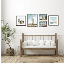 Wanddekoration mit fünf gerahmten Bildern über einer Holzbank mit Kissen