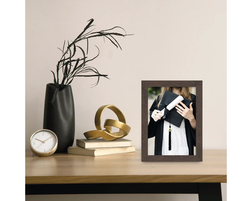 Dekorativer Fotorahmen aus Holz auf einem Tisch mit weiteren Dekorationselementen