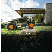 Ein Rasenmähroboter überwindet einen 6 Zentimeter hohen Bordstein.