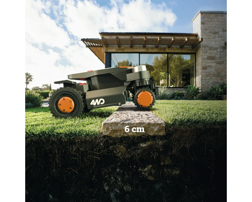 Ein Rasenmähroboter überwindet einen 6 Zentimeter hohen Bordstein.