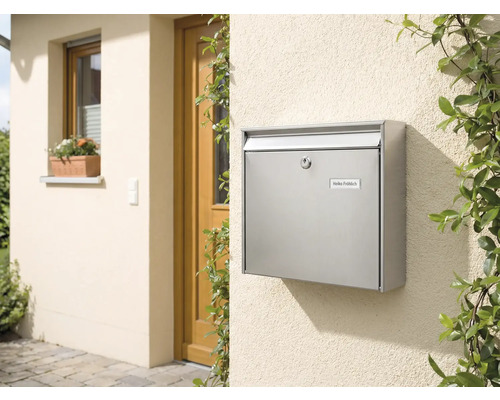 Briefkasten aus Edelstahl an einer Hauswand neben einer Tür