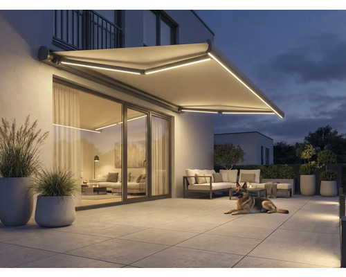 Beleuchtete Markise über einer Terrasse mit Gartenmöbeln und einem Hund