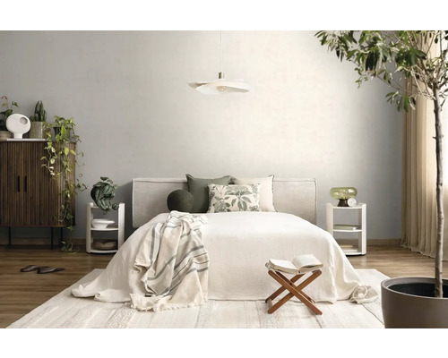 Helles, organisiertes Schlafzimmer mit Bett, weißer Pendelleuchte, Holzmöbeln und Zimmerpflanzen. Verwendung von natürlichen Textilien und Holz.