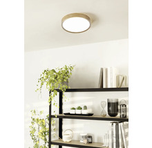 Deckenleuchte mit Holzumrandung in einem hellen Raum über einem Regal.