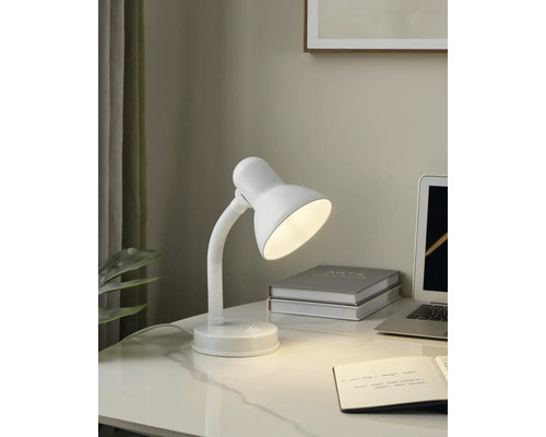 Schreibtischszene mit einer weißen Schreibtischlampe, einem Notizbuch und einem Laptop