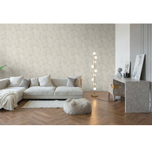 Helles Wohnzimmer mit floral gemusterter Vliestapete, Holzparkett im Fischgrätmuster, modernem Sofa und einer Stehlampe.