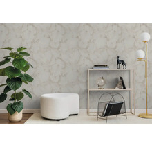 Modernes Wohnzimmer mit strukturierter Tapete in Marmor-Optik, einer großen Grünpflanze, einem weißen Hocker und einem minimalistischen Regal.