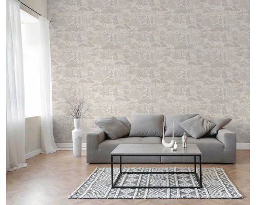 Wohnzimmer mit Vliestapete in Waldoptik, grauem Sofa, Couchtisch und gemustertem Teppich.