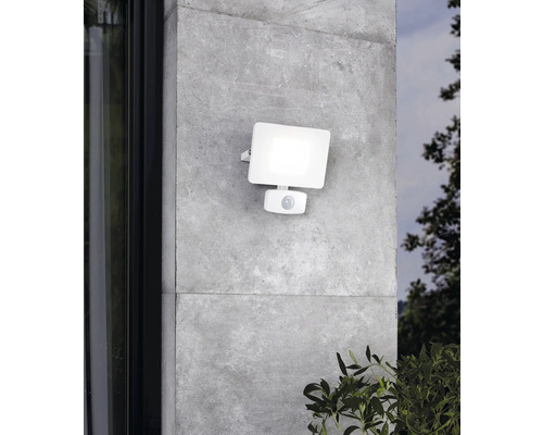 Weiße Außenleuchte mit Bewegungsmelder an einer grauen Wand