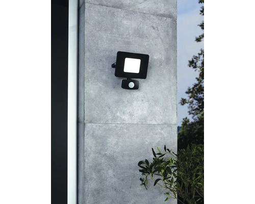 Schwarzer LED-Außenstrahler mit Bewegungsmelder an einer Wand montiert.