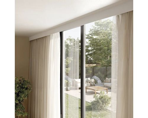 Innenraum mit Vorhängen und Blick auf eine Terrasse mit Gartenmöbeln