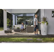 Moderner Terrassenbereich mit grauen Polyrattan-Gartenmöbeln, einer weißen Regentonne mit integriertem Pflanzgefäß und zwei Personen.