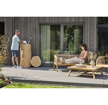 Moderner Außenbereich mit einer Holzterrasse, Gartenmöbeln aus Holz und einem dekorativen Regenwasserbehälter in Baumstamm-Optik.