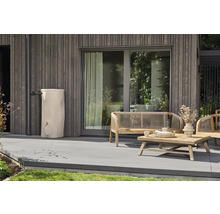 Moderner Außenbereich mit einer Regentonne in Baumstamm-Optik, Holzterrasse und Gartenmöbeln vor einer vertikalen Holzfassade.