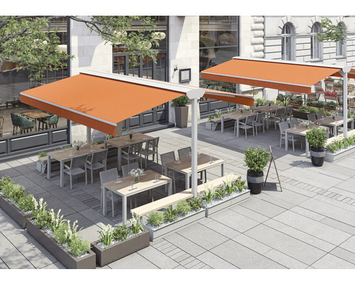 Außenbereich eines Restaurants mit Sonnensegeln und Sitzgelegenheiten.